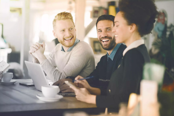 Header image of AS Varbas success story showing a casual business meeting with three people